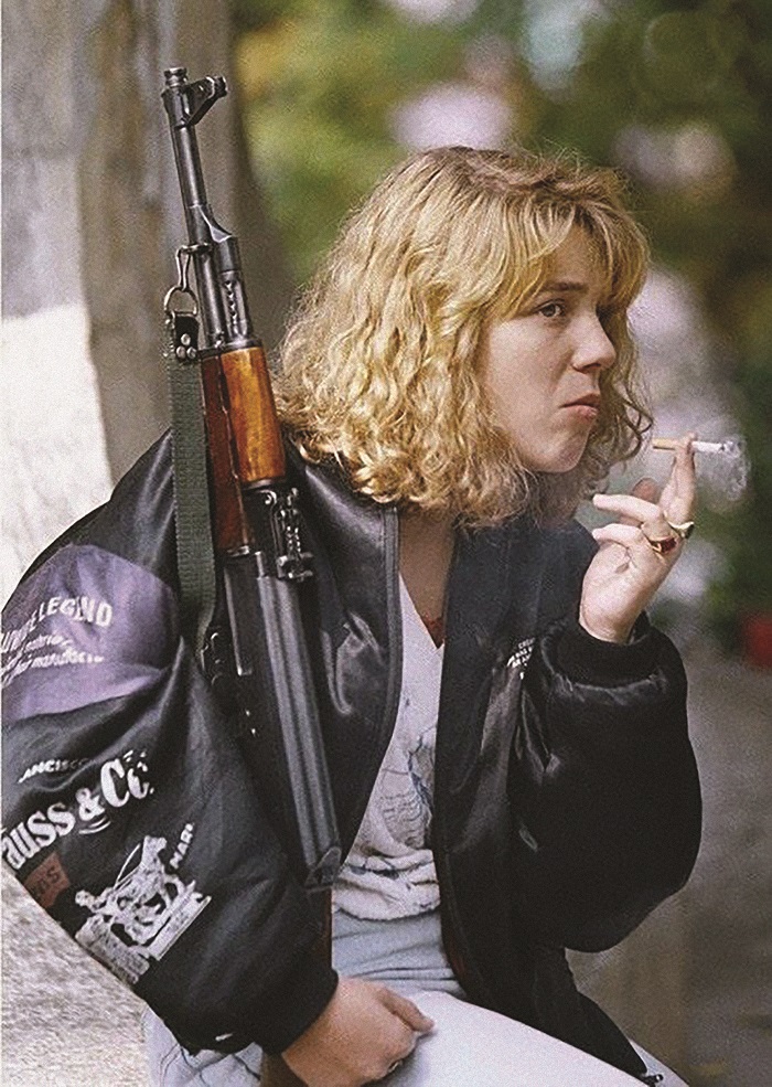 a-bosnian-girl-holding-an-ak-47-rifle-smokes-a-cigarette-as-she-waits-for-a-funeral-service-at-sarajevo-s-lion-s-cemetery-on-monday-sept-1654280479. 14, 1992.jpg